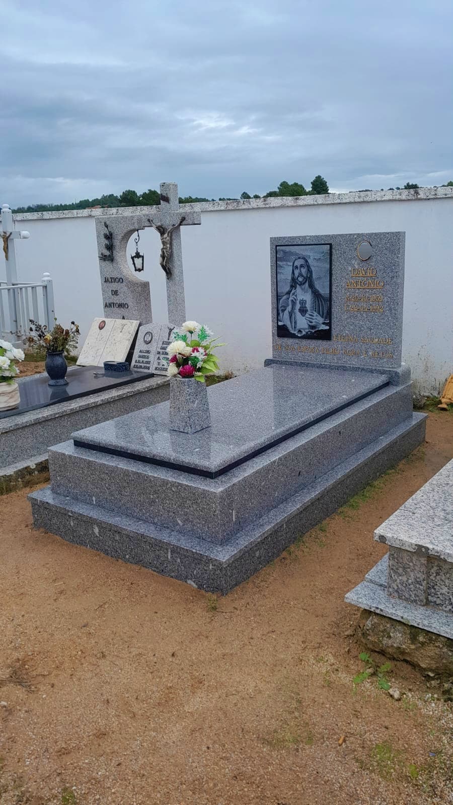 Jazigo simples em granito cinza com cabeceira gravada